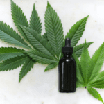 Tincture bottle laying flat on cannabis leaves