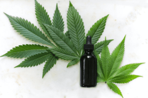 Tincture bottle laying flat on cannabis leaves