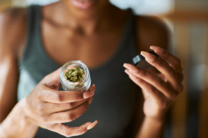 Woman opening jar of cannabis